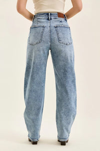 Light blue jeans worn by a person on a beige background