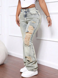 Person wearing light blue distressed jeans with a white background