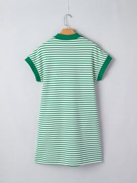 Green and white striped dress on a hanger against a light gray background