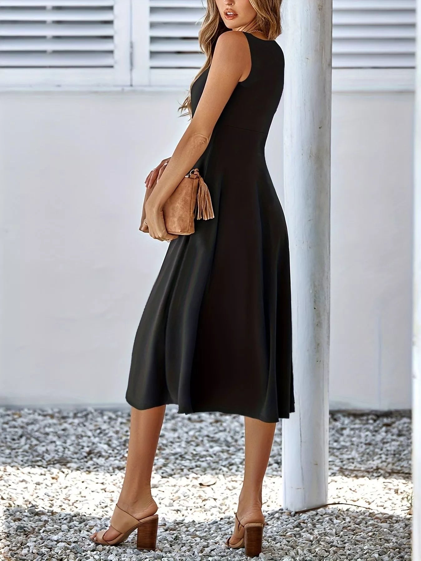 Woman wearing a black sleeveless dress with a white background