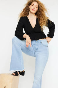 Woman wearing a black top and light blue jeans on a white background