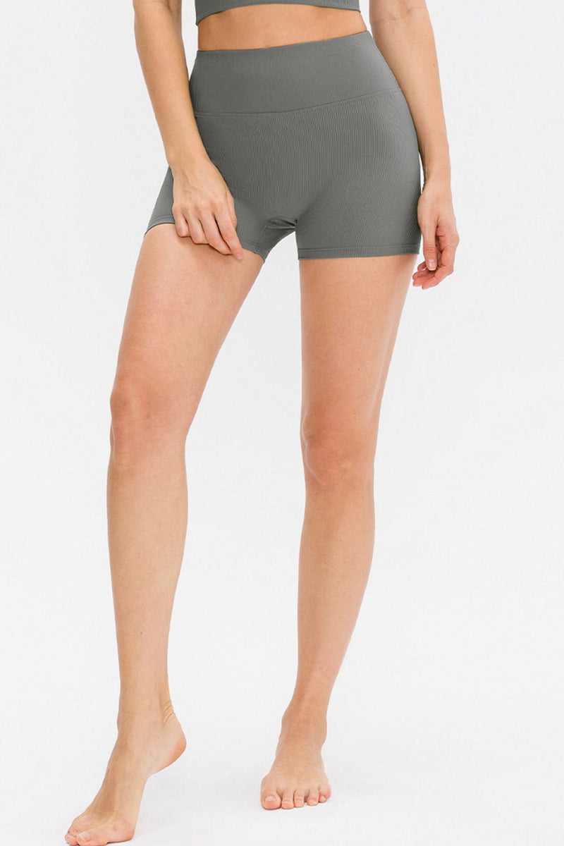 Person wearing gray high-waisted shorts on a white background