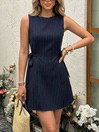 Woman wearing a navy pinstripe dress with a white background and decorative elements.