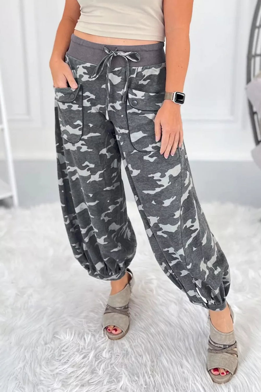 Person wearing gray camouflage pants on a white background