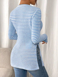 Person wearing a blue and white striped sweater against a white curtain background