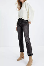 Person wearing a white sweater and black jeans on a white background