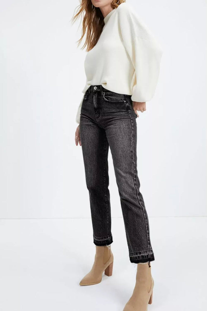 Person wearing a white sweater and black jeans on a white background