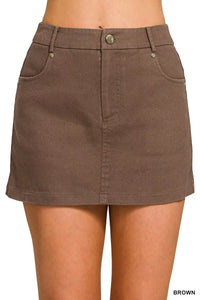 Brown denim skirt worn by a person on a plain background