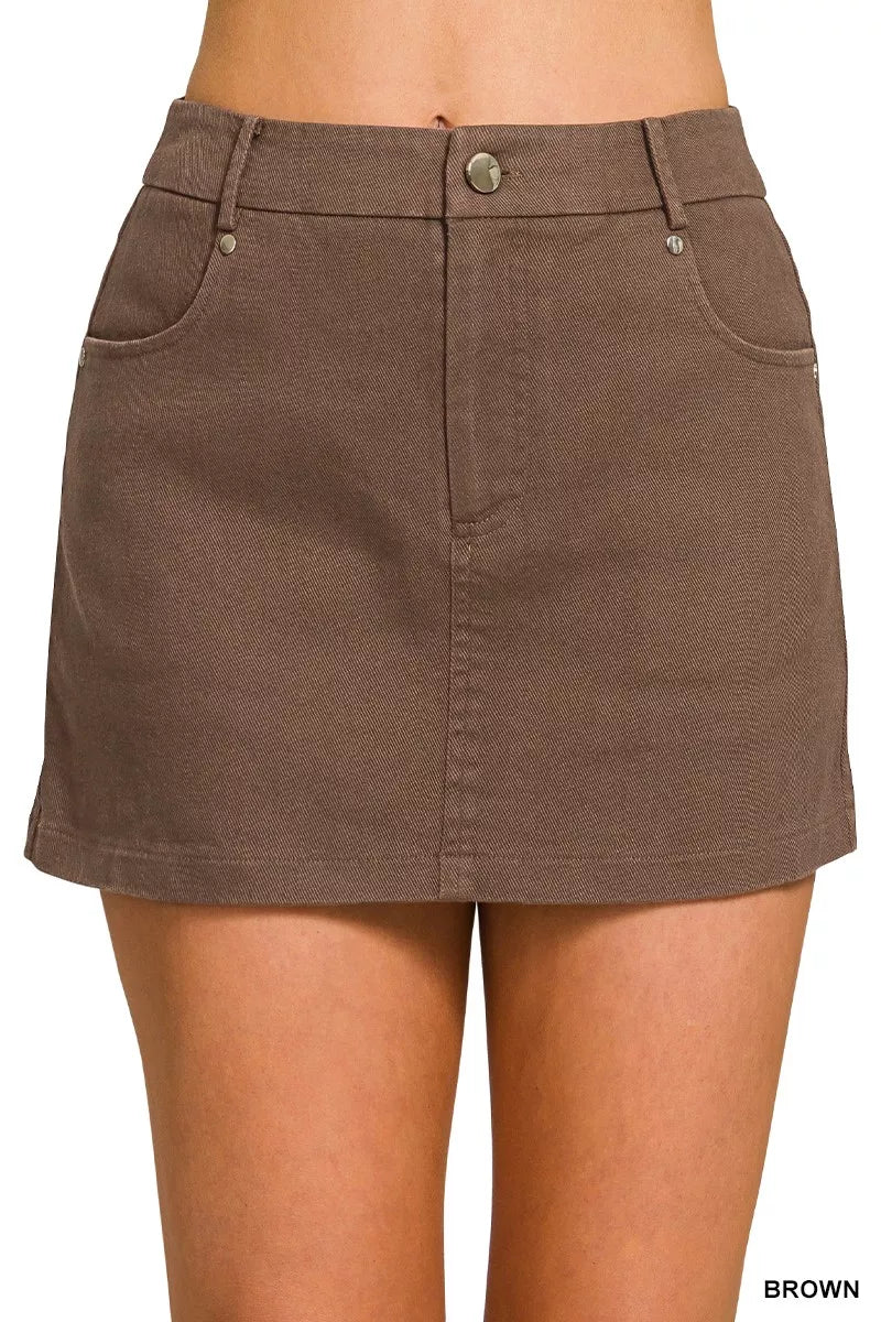 Brown denim skirt worn by a person on a plain background