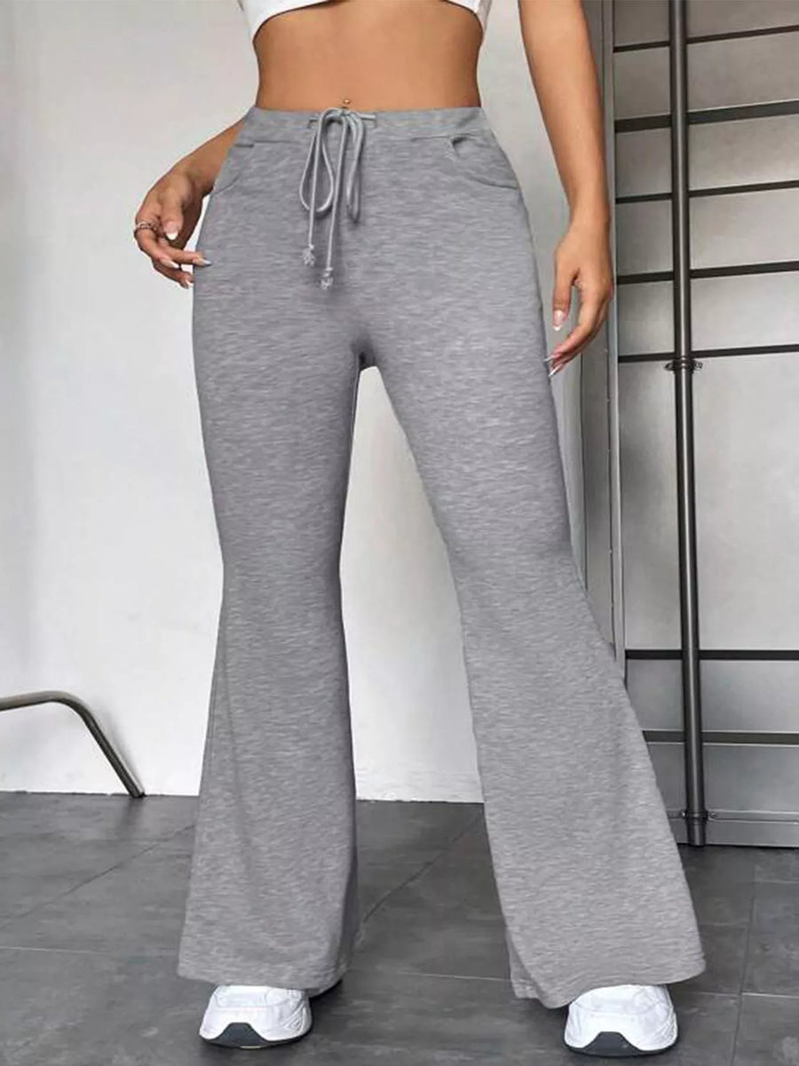 Gray flared pants worn by a person on a neutral background