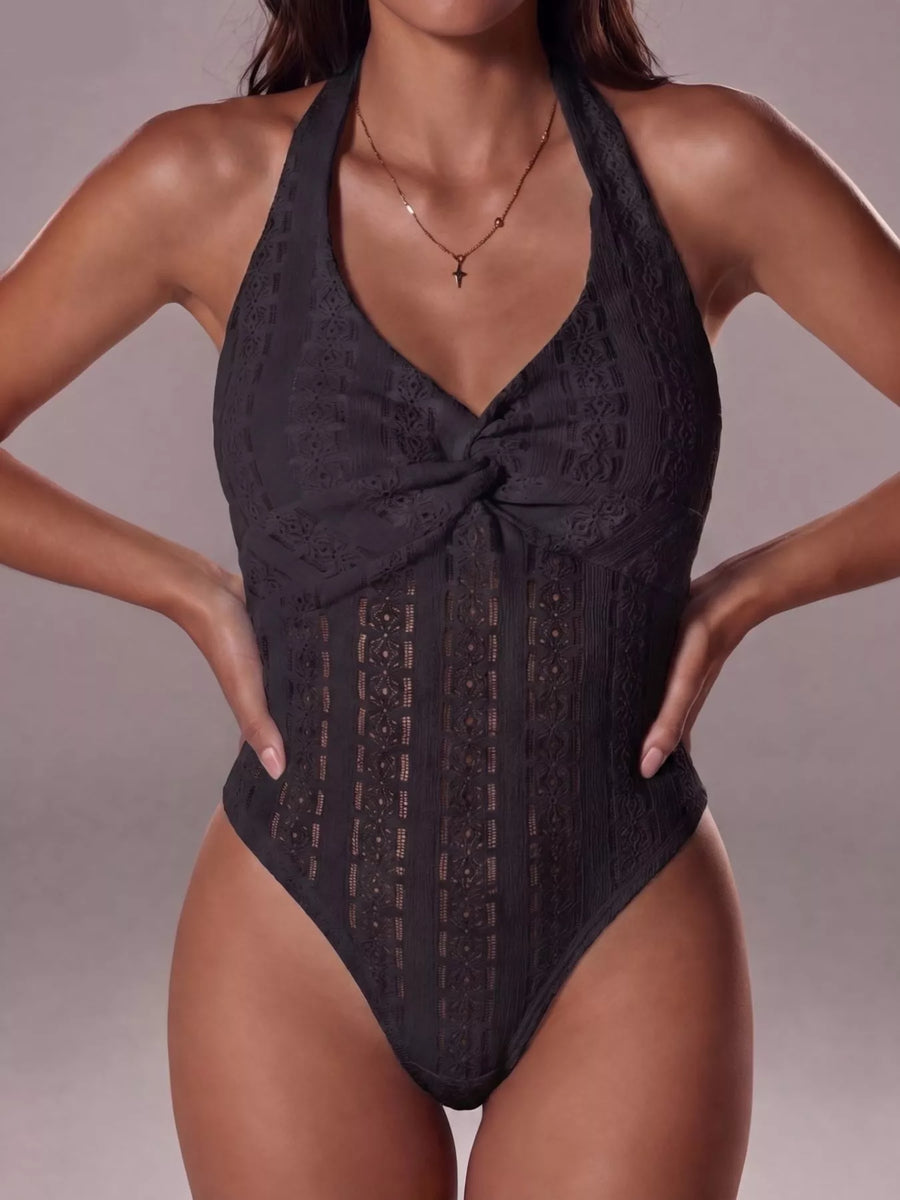 Black lace halter neck swimsuit on a neutral background