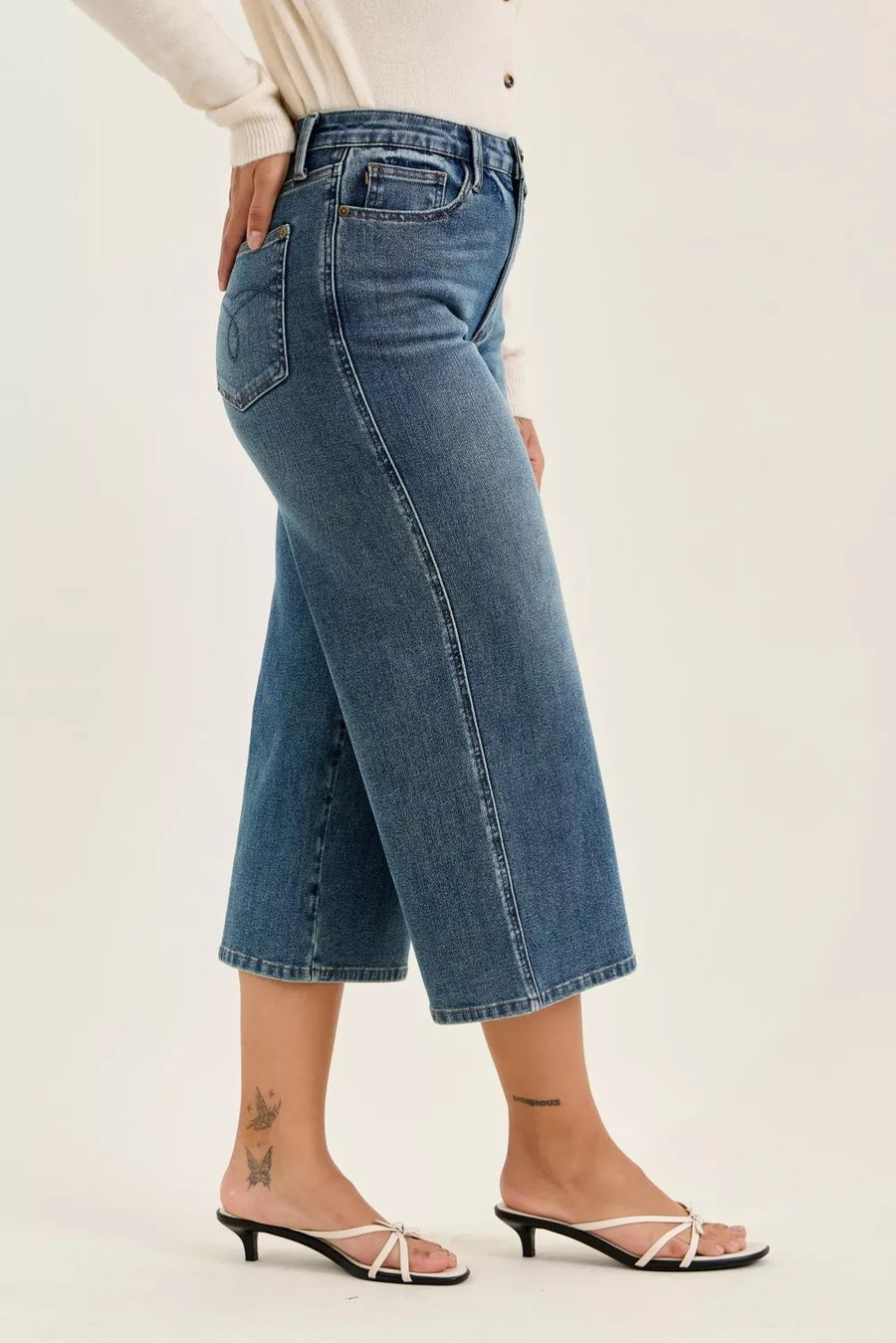 Blue jeans worn by a person on a white background