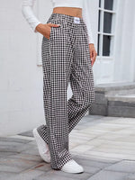 Person wearing black and white checkered pants with a white background