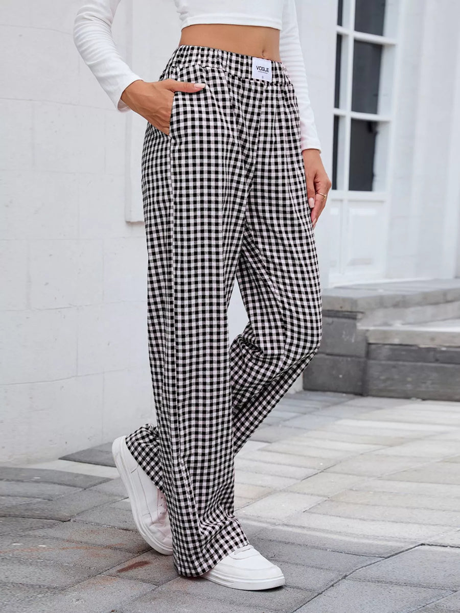 Person wearing black and white checkered pants with a white background