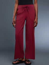 Maroon wide-leg pants worn by a person on a gray background