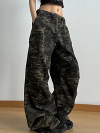 Camouflage pants worn by a person on a plain background