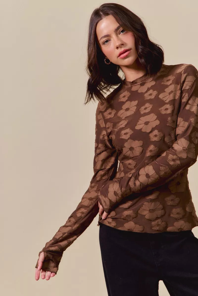 Woman wearing a sheer brown leopard print top against a beige background