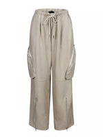 A pair of wide-leg cargo pants in a light beige or sand color, featuring an elastic waistband with a drawstring, large zippered side cargo pockets, and zippered pockets on the lower legs, shown against a plain white background.