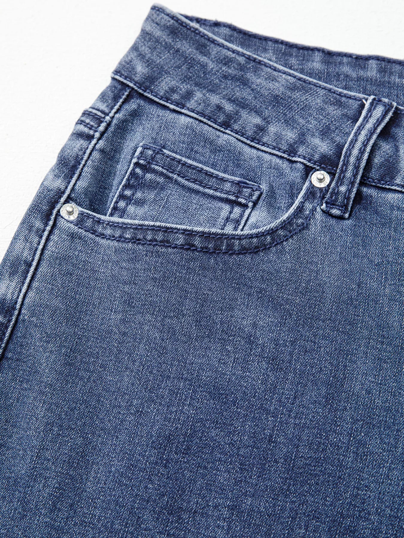 Close-up of blue denim jeans with a focus on the pocket area.
