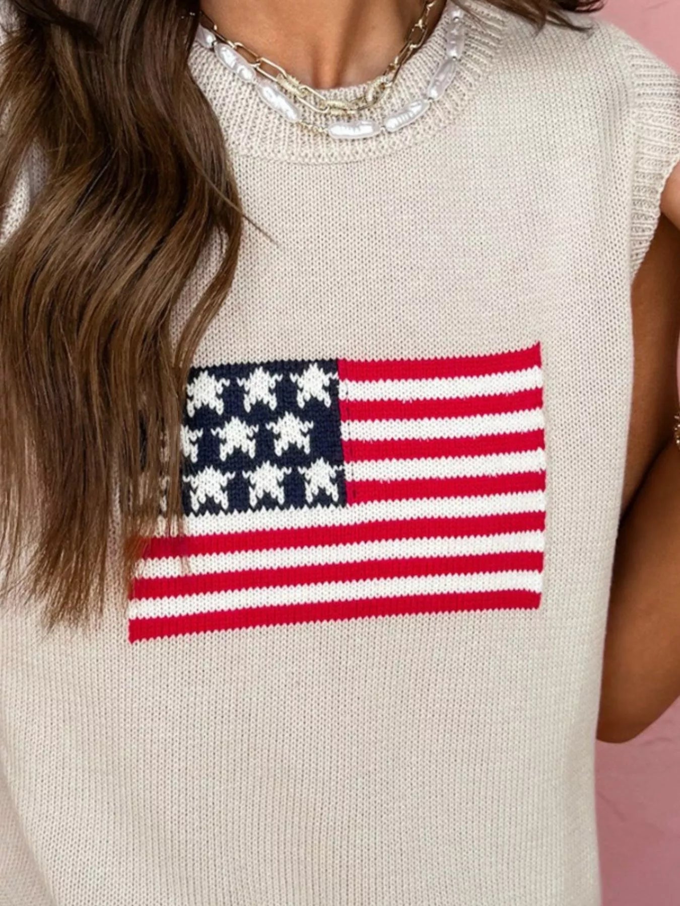 Beige sleeveless sweater with American flag design on a pink background