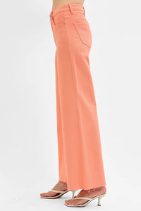 Coral pants worn by a person on a white background