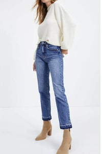 Person wearing a white sweater and blue jeans on a white background
