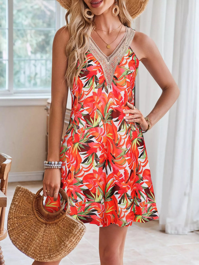 Woman wearing a red floral dress holding a straw bag indoors.