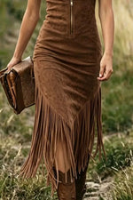 Brown suede dress with fringe and matching clutch held by a person in a natural setting