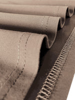 Close-up of a roll of brown fabric with stitching details.