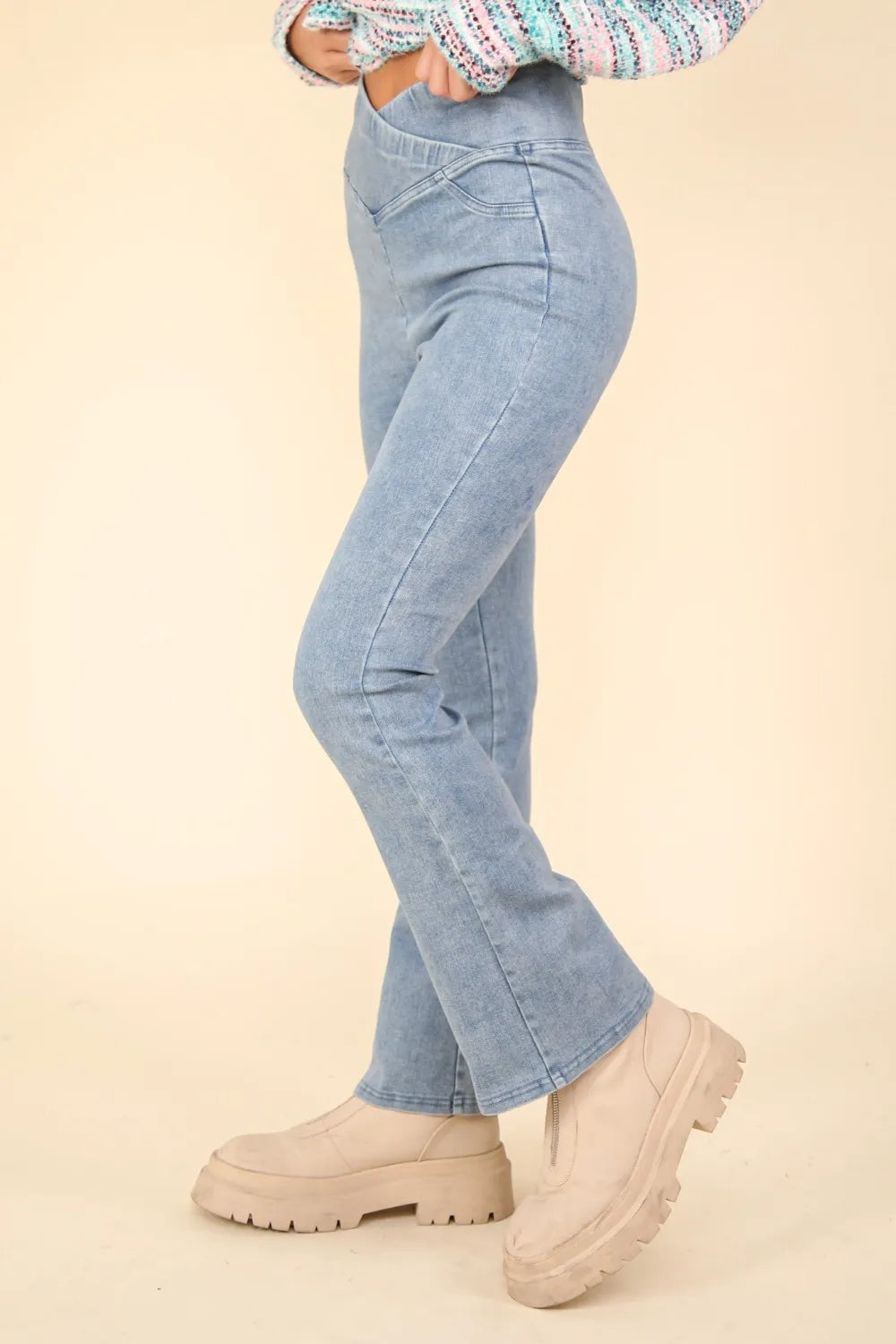 Light blue jeans worn by a person on a beige background