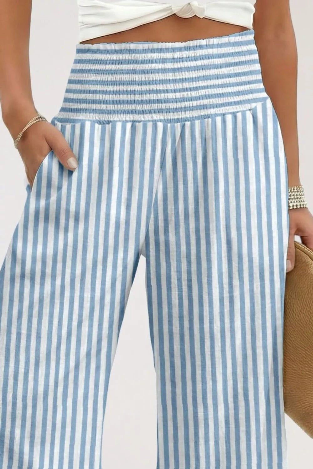 Blue and white striped pants worn by a person on a plain background