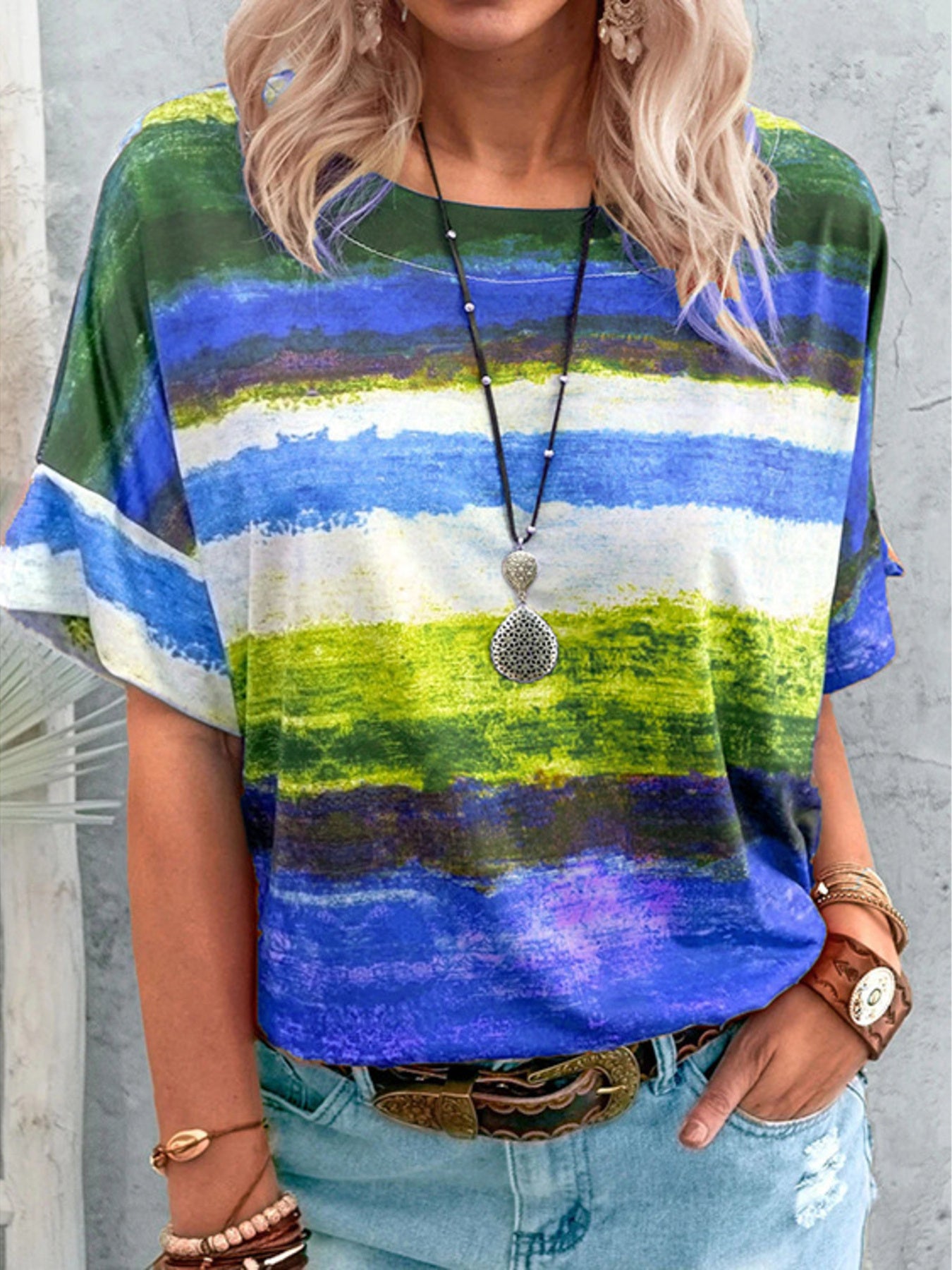 Person wearing a colorful striped shirt with a neutral background
