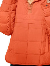 Close-up of an orange puffer jacket on a white background