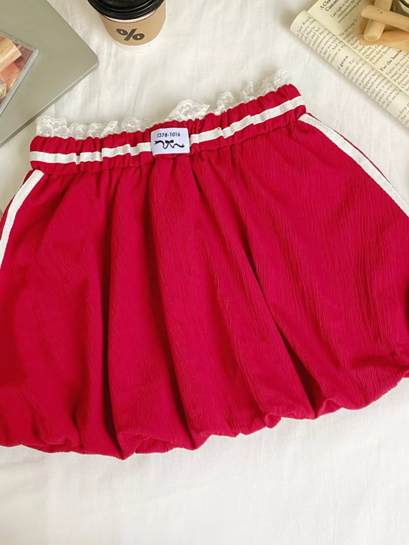 Red skirt with white trim on a white surface