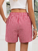 Red and white checkered shorts worn by a person with a blurred background