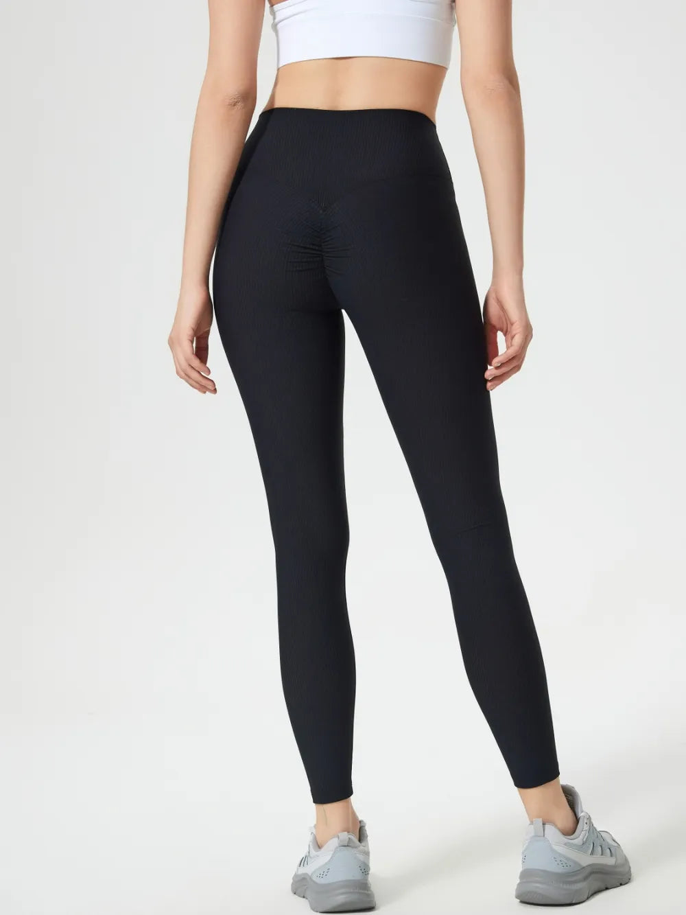 Person wearing black leggings on a white background