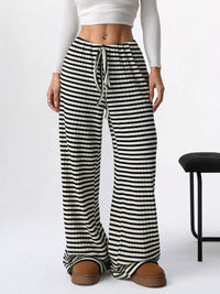 Black and white striped pants worn by a person on a white background