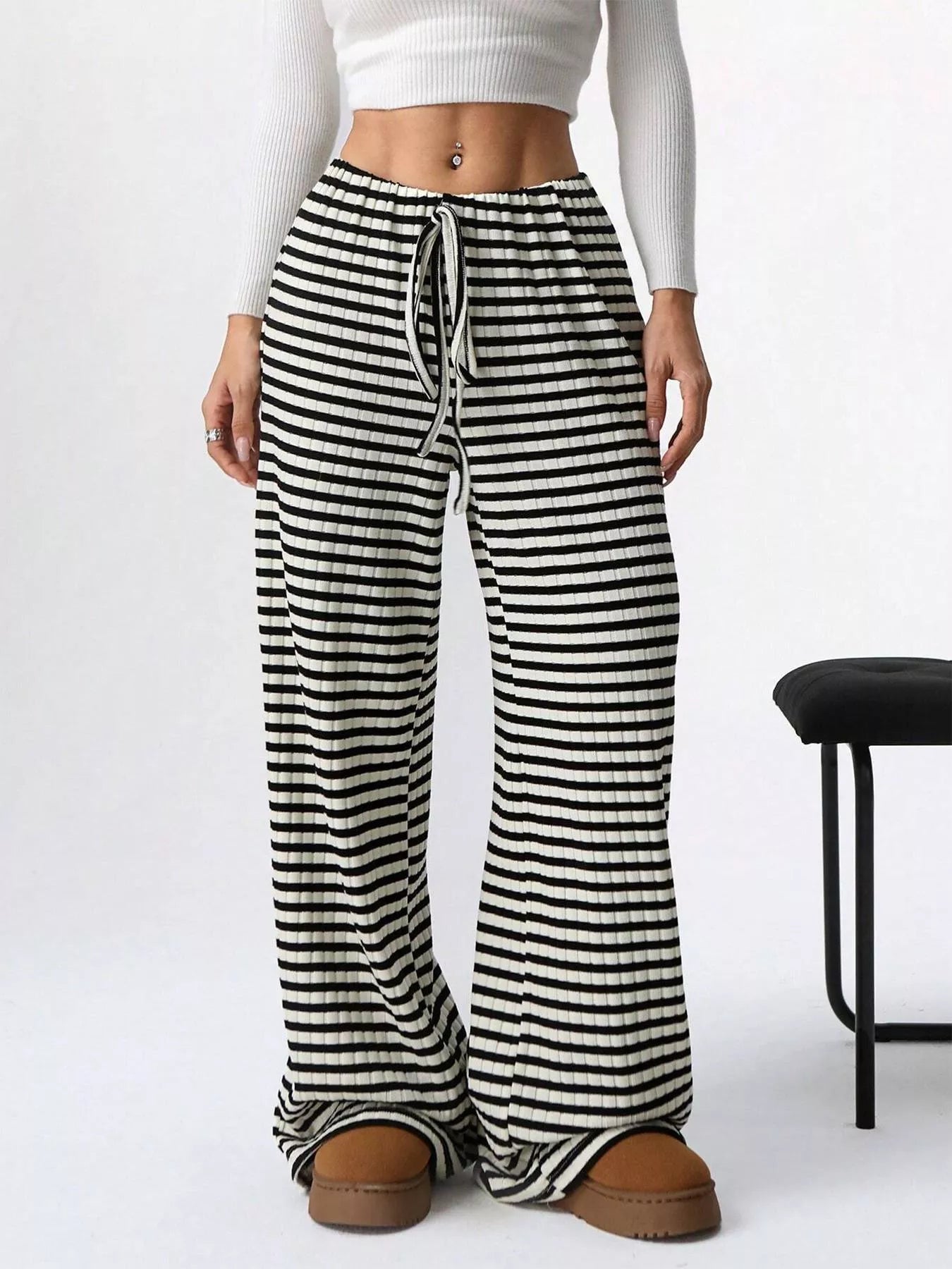 Black and white striped pants worn by a person on a white background