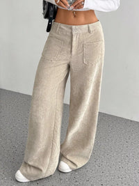 Beige corduroy wide-leg pants worn by a person on a gray floor.