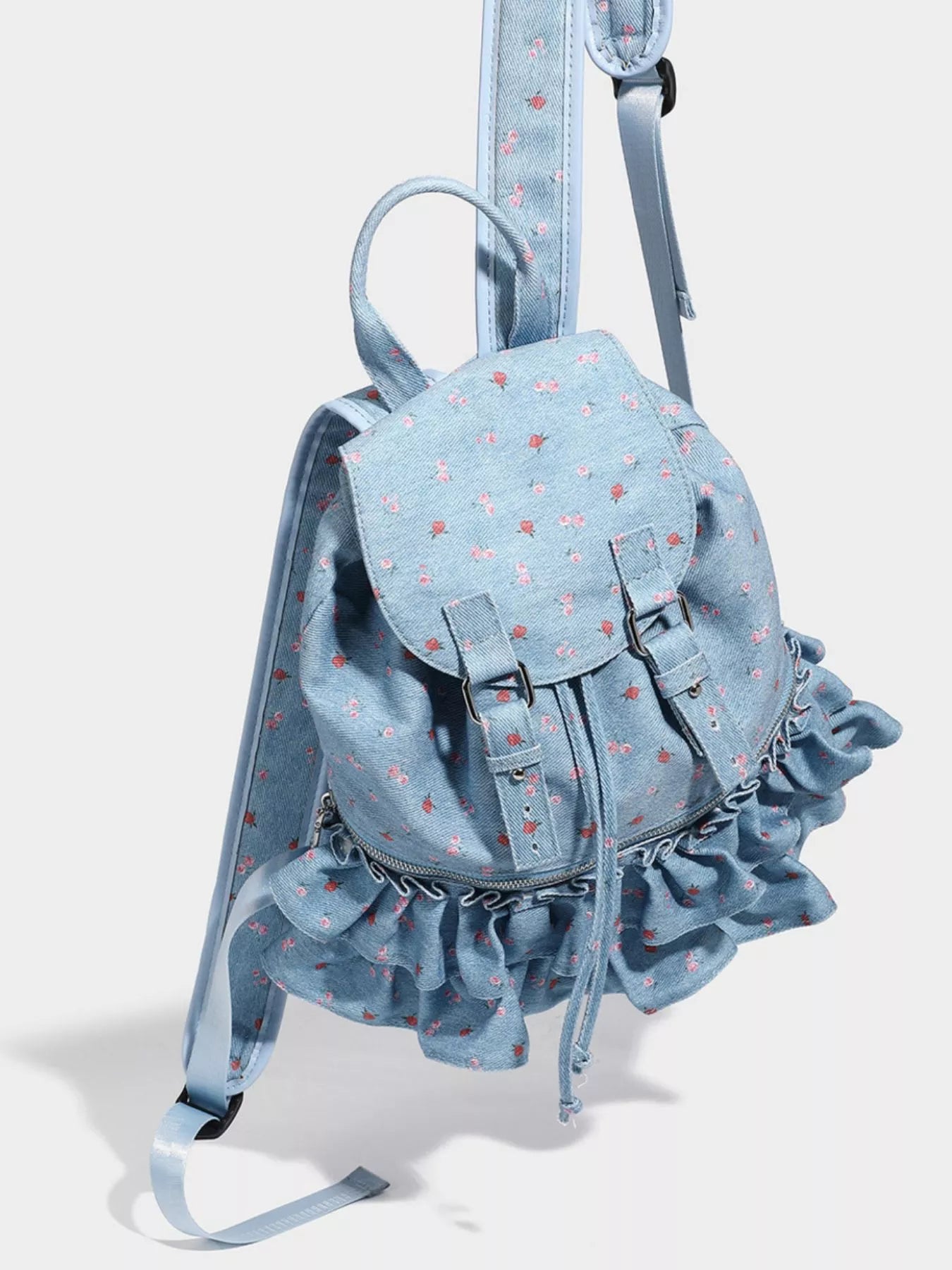 Light blue denim backpack with ruffles on a white background