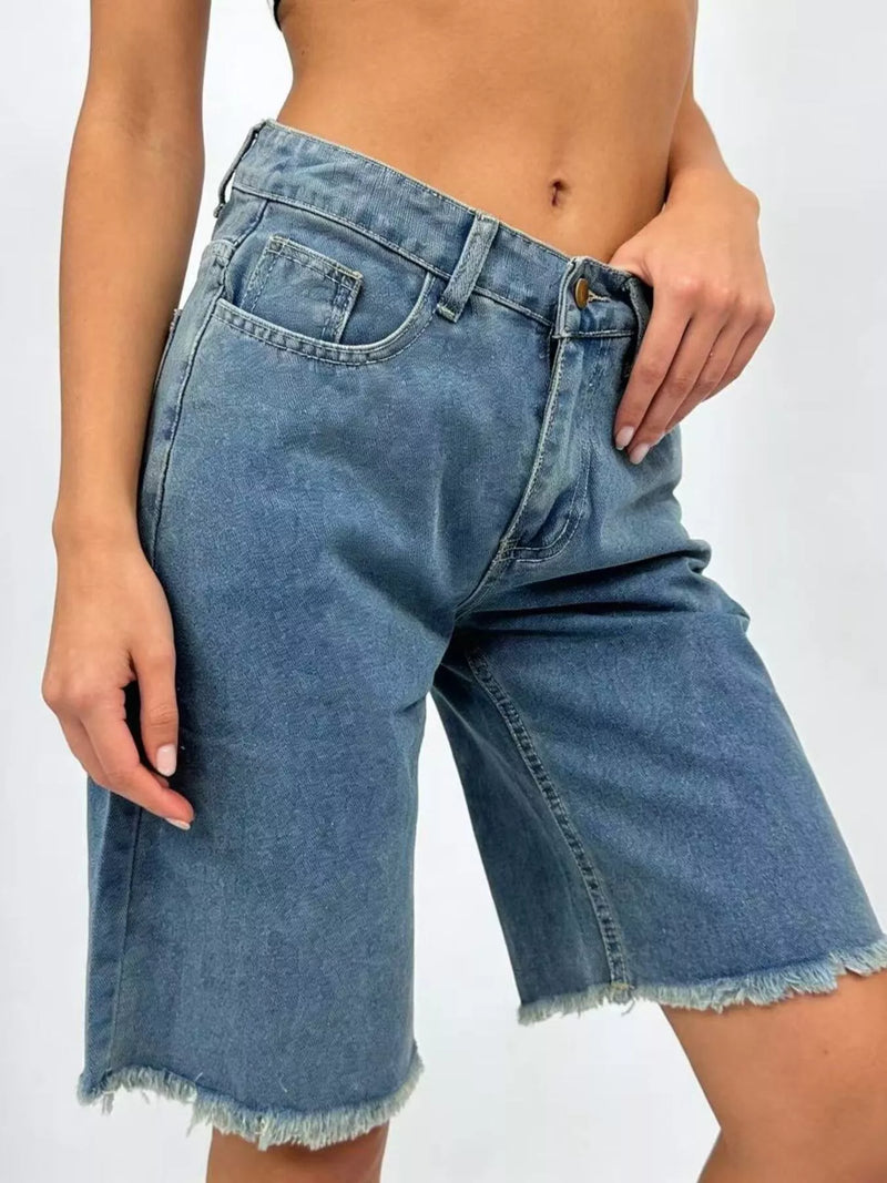 Denim shorts worn by a person on a white background