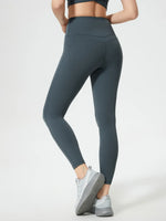 Person wearing dark gray leggings on a white background