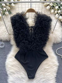 Black ruffled swimsuit on a fluffy white rug