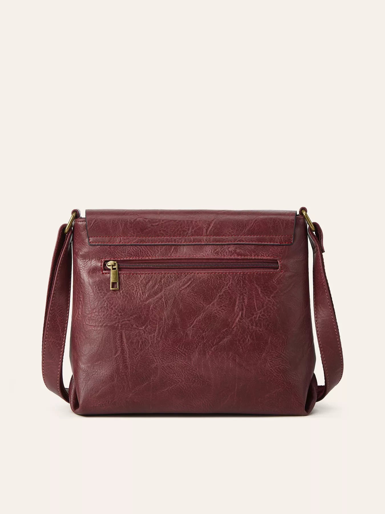 Brown leather crossbody bag on a beige background