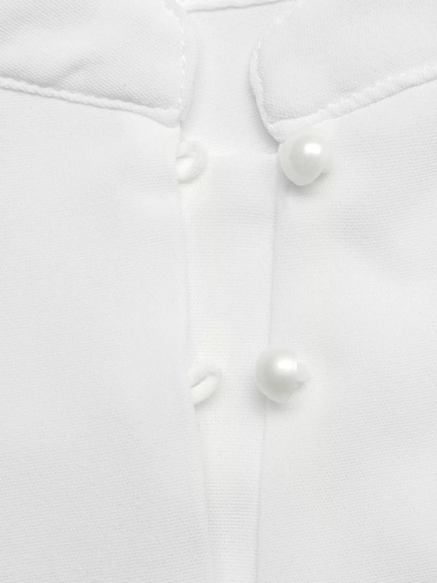 Close-up of a white buttoned shirt with pearl-like buttons on a light gray background