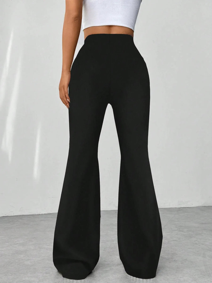 Black flared pants worn by a person on a plain background