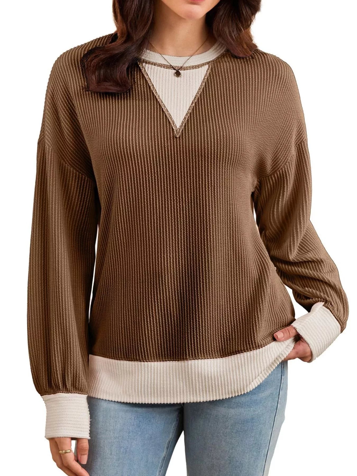 Brown ribbed sweater with white trim worn by a person on a white background