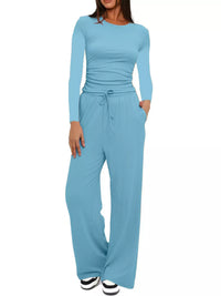 Woman wearing a light blue jumpsuit on a white background