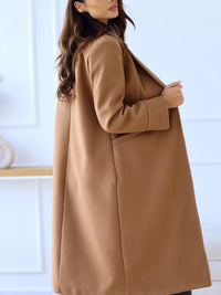 Woman wearing a brown coat against a white background