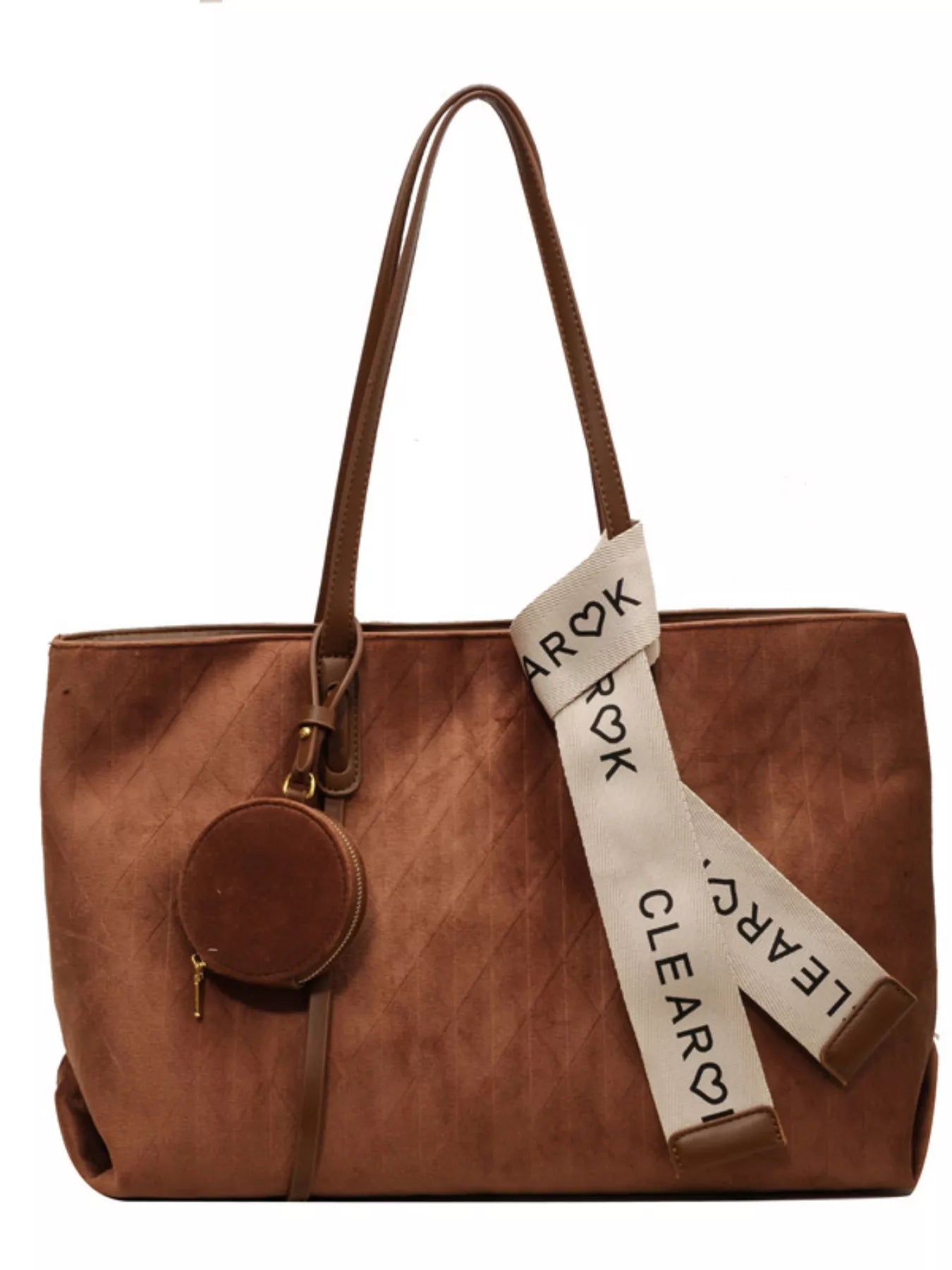 Brown leather tote bag with a decorative strap on a white background